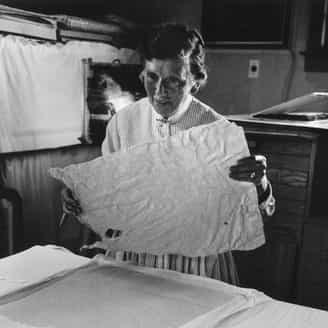 Tatyana Grosman examining a sheet of hand-made India paper. This unusual paper was used for Jasper John's Flags and Targets.