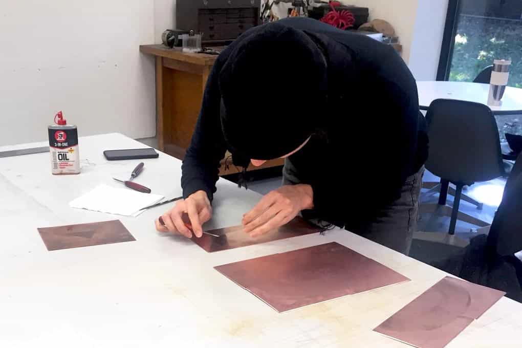 Nathlie Provosty working on multiple plates with etching tools.