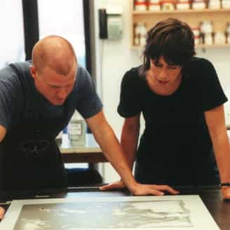 Doug Bennett and Cecily Brown looking at a photo litho plate on the press.