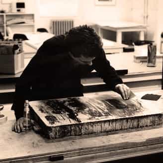 Carroll Dunham at the lithography press drawing on a lithographic stone for his first print Red Shift.