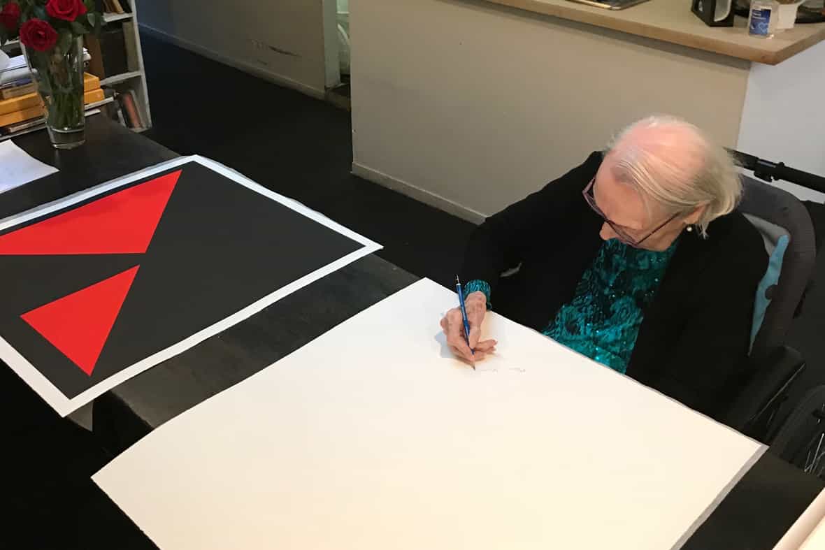 Artist Carmen Herrera signing a printed edition, Island.