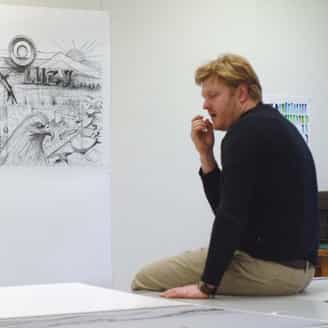 Jason Middlebrook examining a proof of his print Lucy's Wild Wild West which hangs on the wall.