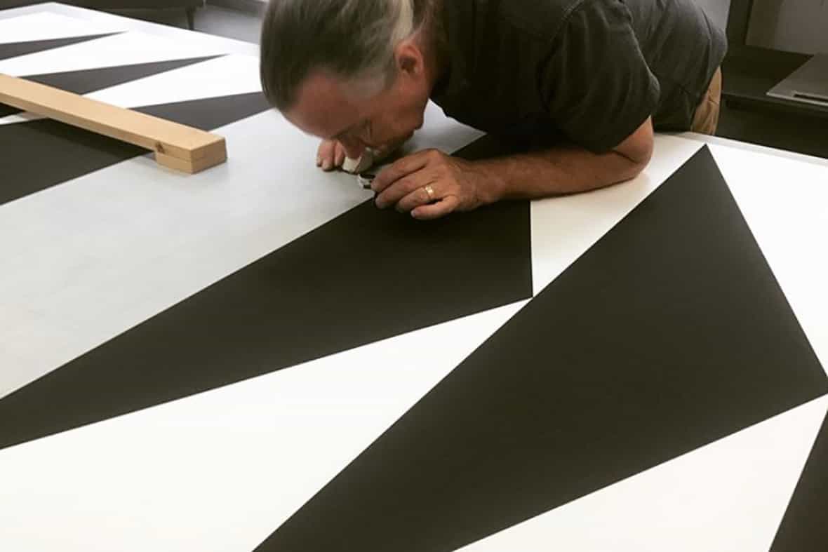 A man looking through a loop to curate a printed edition.