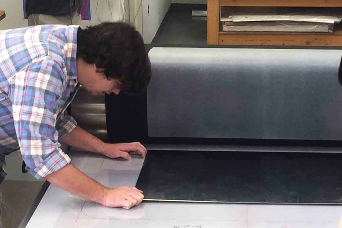 Steven Fournier preparing to print on the black paper with chine-collé. Printmaker Steven Fournier preparing to print the etching plate on the black paper with chine-collé for Jasper Johns "Regrets."