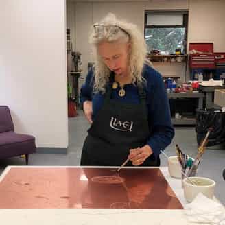 Kiki Smith painting acid onto a copper plate as part of Sorcery.