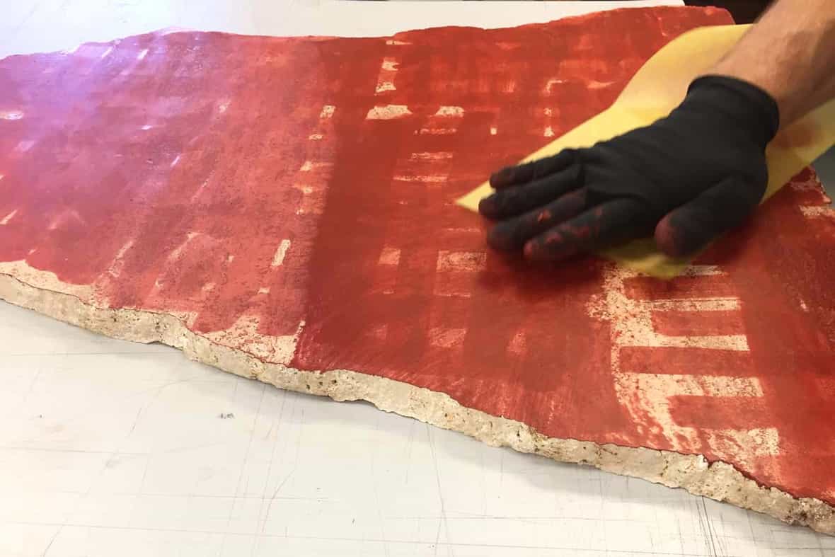 Printer Brian Berry wiping a repurposed stone to print as an etching.